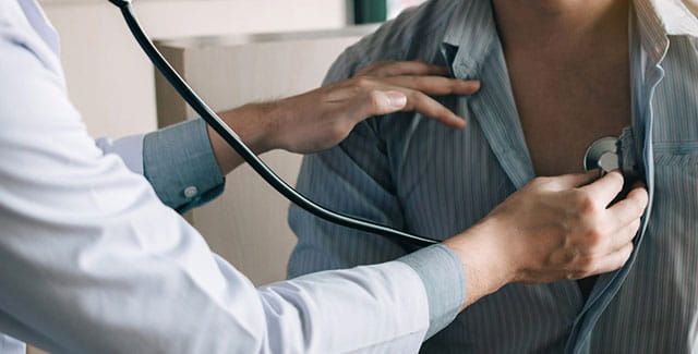 Doctor checking patient's heart.