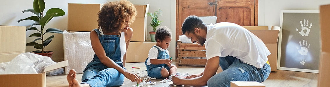 Family sitting on the floor of their new home.