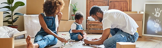 Family sitting on the floor of their new home.