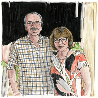 Libby sits in a wheelchair holding a microphone and reading from a piece of paper.