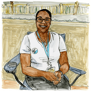 Sara stands at a table with a yellow bridge behind her. 