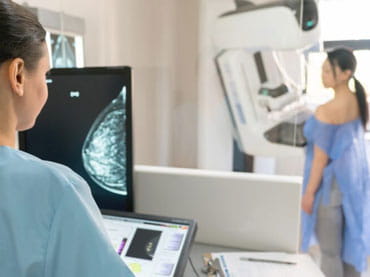 Doctor performs mammogram scan on patient